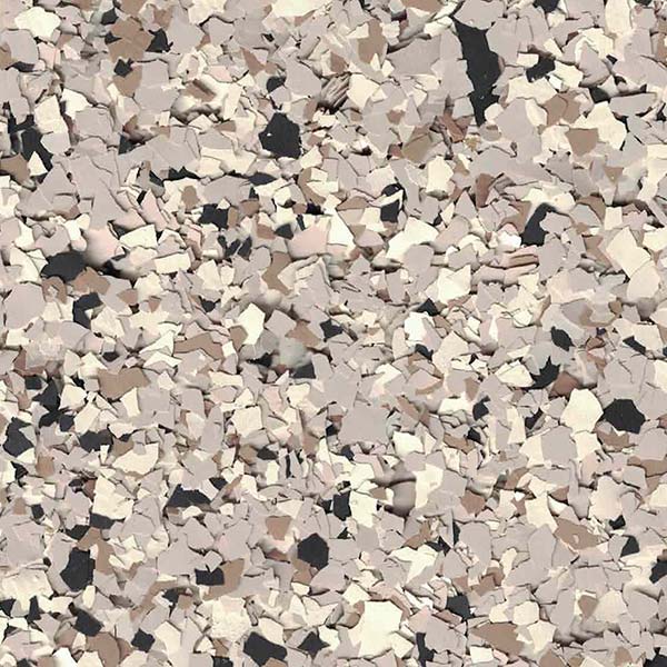 The image shows a close-up of a textured surface with scattered beige and brown flakes, resembling stone or gravel. No people or landmarks.